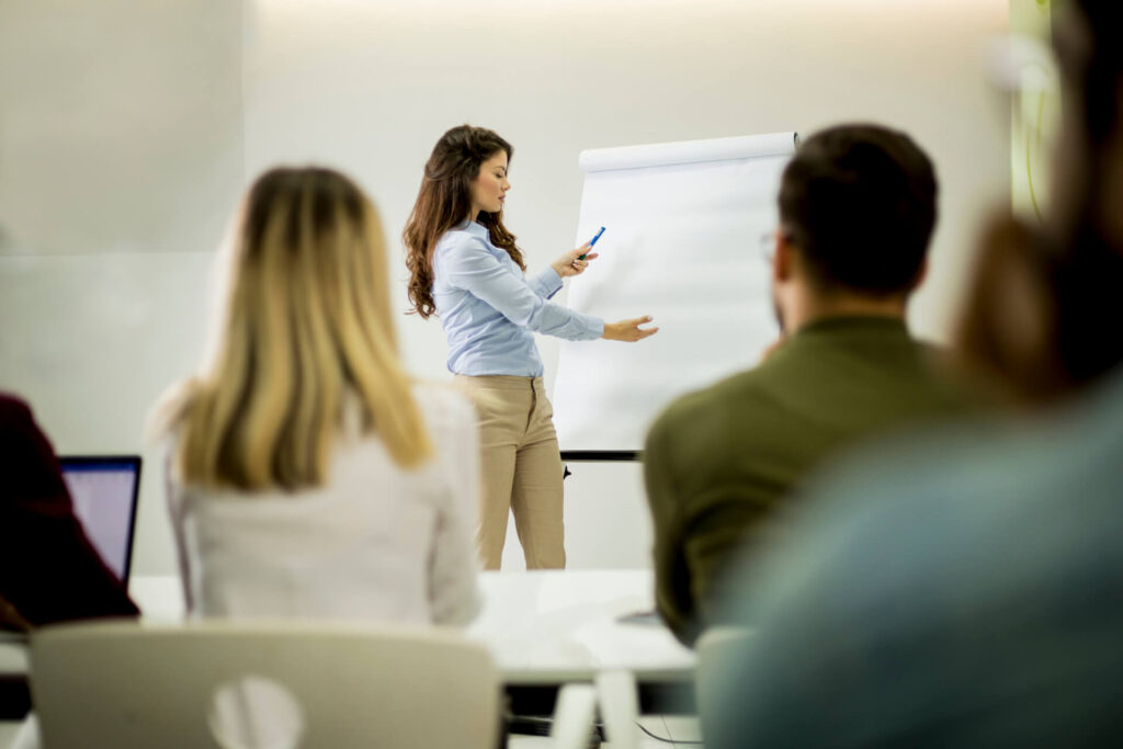 Formatrice che tiene una lezione in aula davanti a un gruppo di partecipanti